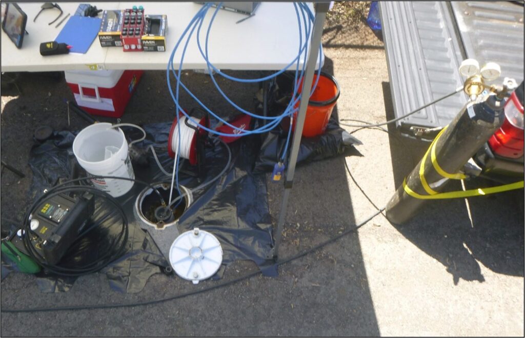 Groundwater sampling equipment arranged around a monitoring well.